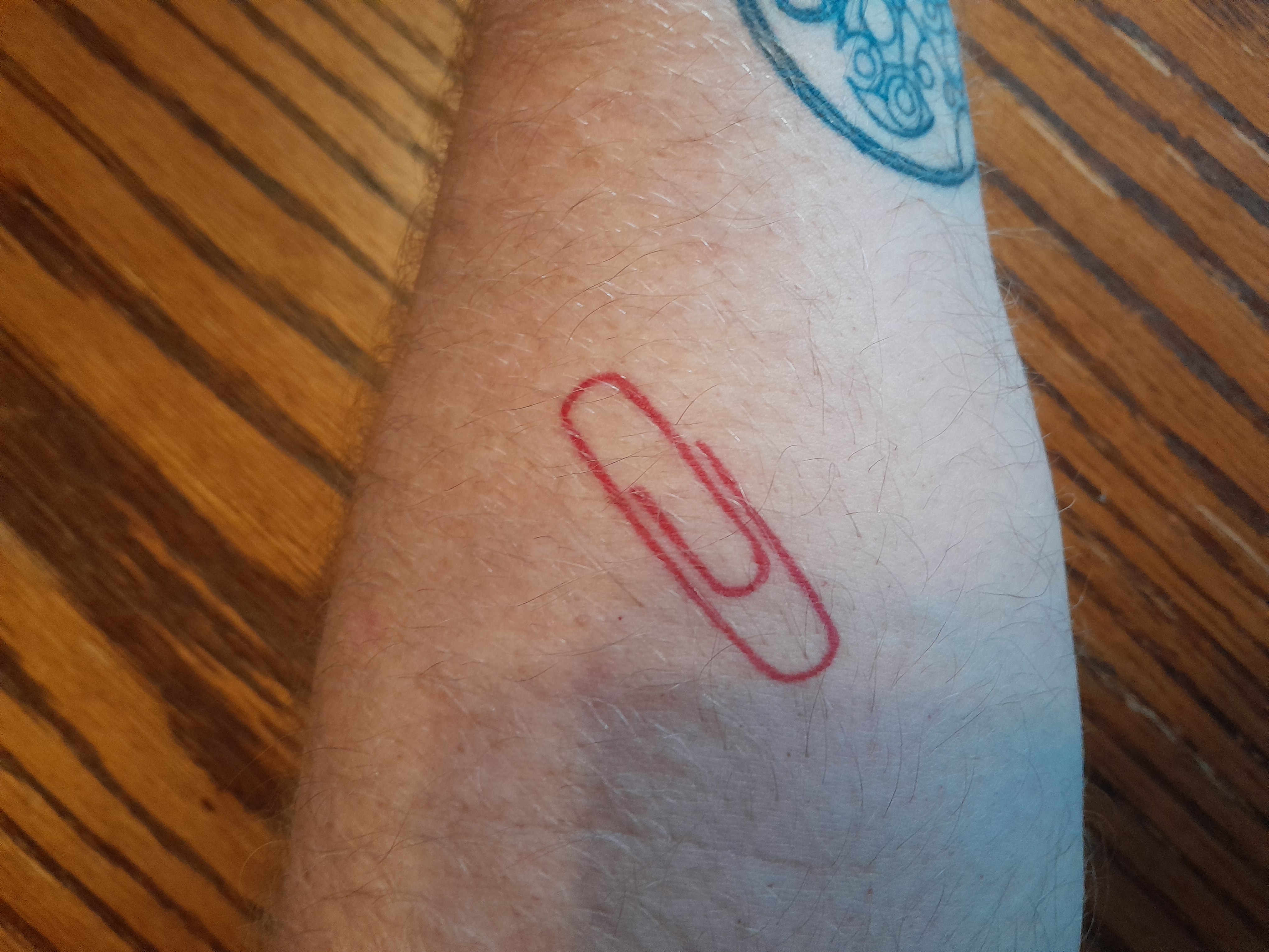 Tattoo of a red paperclip