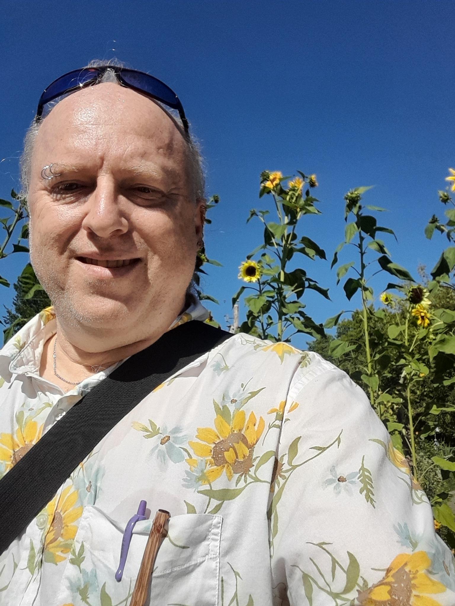 Dethe selfie in a sunflower shirt with sunflowers in the background